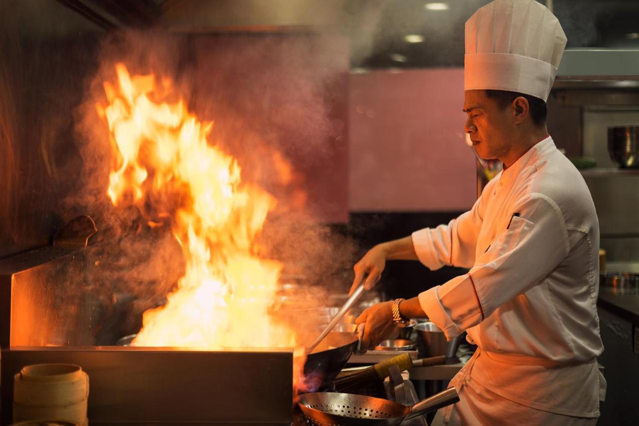 The Berkeley Hotel Pratunam Bangkok Exteriér fotografie A chef cooking with a wok